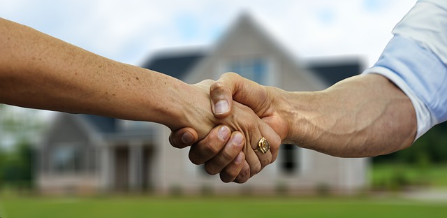 Real Estate Profession and Buyer Shaking Hands in Front of a House for Sale in Winston-Salem NC